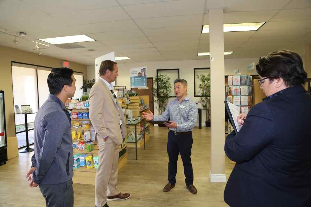 Congressman Rouda at harbor compounding pharmacy with Mike Hua and two more men in the lab