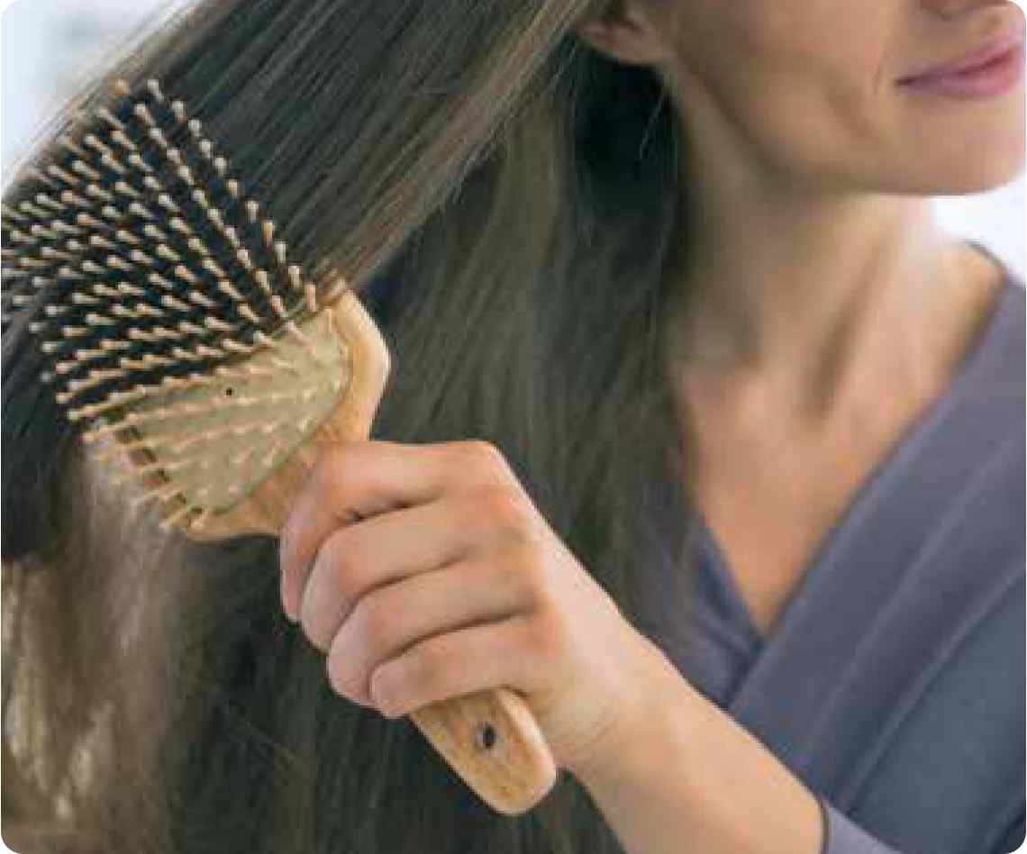 girl brushing through her long thick hair