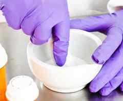 a person in purple gloves mixing something in a bowl