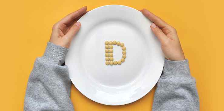 a person holding a plate with pills on it